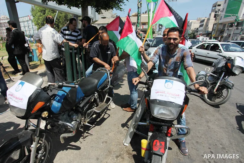 Palestinians ride motorcycles and carry the Palestinian flag during a demonstration organized by the National Authority for Return and Breaking the Siege in Gaza City, June 5, 2018. Photo by Mahmoud Ajour