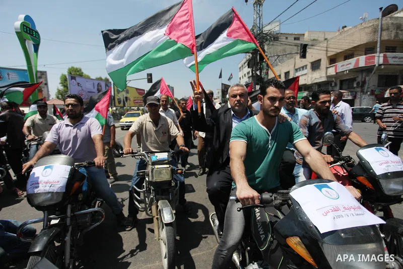Palestinians ride motorcycles and carry the Palestinian flag during a demonstration organized by the National Authority for Return and Breaking the Siege in Gaza City, June 5, 2018. Photo by Mahmoud Ajour
