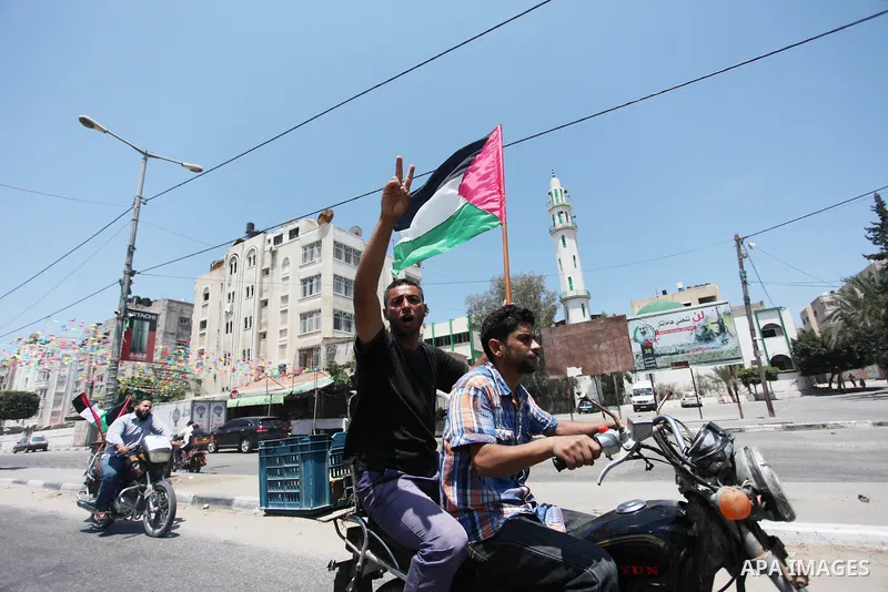 Palestinians ride motorcycles and carry the Palestinian flag during a demonstration organized by the National Authority for Return and Breaking the Siege in Gaza City, June 5, 2018. Photo by Mahmoud Ajour