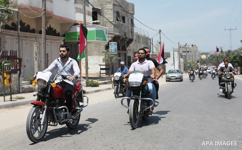 Palestinians ride motorcycles and carry the Palestinian flag during a demonstration organized by the National Authority for Return and Breaking the Siege in Gaza City, June 5, 2018. Photo by Mahmoud Ajour