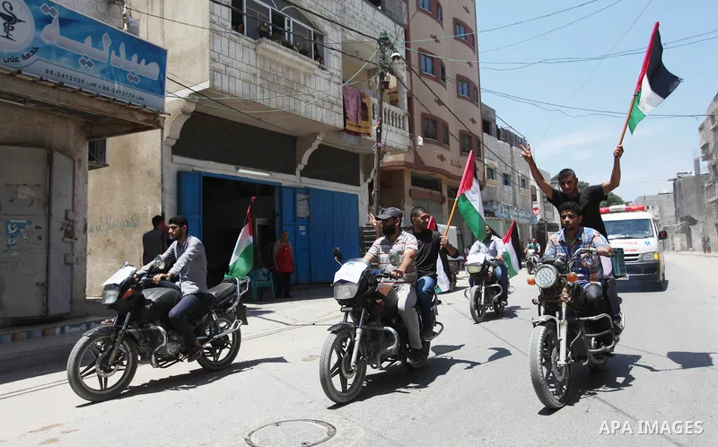 Palestinians ride motorcycles and carry the Palestinian flag during a demonstration organized by the National Authority for Return and Breaking the Siege in Gaza City, June 5, 2018. Photo by Mahmoud Ajour
