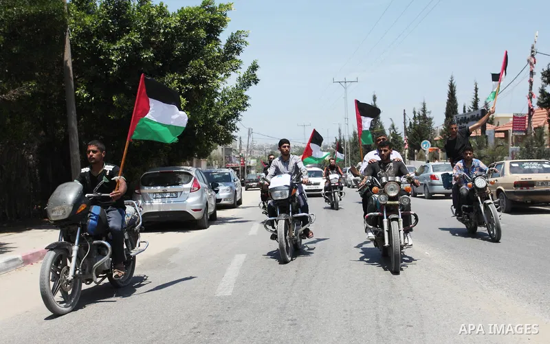 Palestinians ride motorcycles and carry the Palestinian flag during a demonstration organized by the National Authority for Return and Breaking the Siege in Gaza City, June 5, 2018. Photo by Mahmoud Ajour
