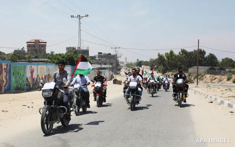 Palestinians ride motorcycles and carry the Palestinian flag during a demonstration organized by the National Authority for Return and Breaking the Siege in Gaza City, June 5, 2018. Photo by Mahmoud Ajour