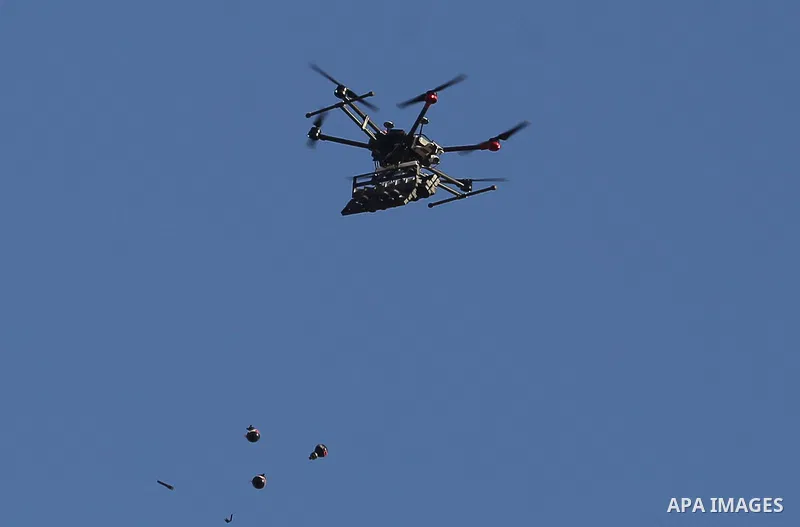 A picture taken 05 June 2018 shows an Israeli quadcopter drone flying over Palestinian protesters and throw tear gas canisters during clashes in a tent city protest where Palestinians demand the right to return to their...