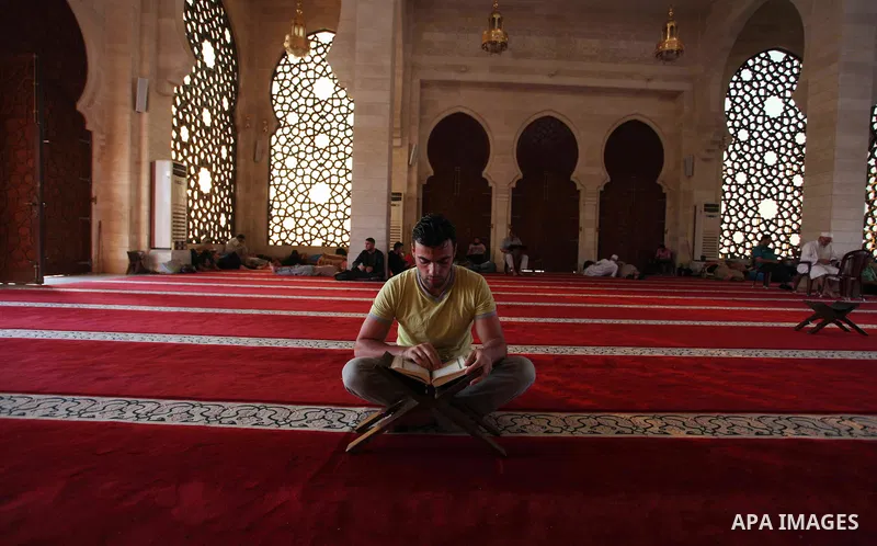 A Palestinian man reads the Koran, Islam's holiest book, at a mosque in Gaza City during the Muslim holy month of Ramadan, on June 6, 2018. Ramadan is sacred to Muslims because it is during that month that tradition says...