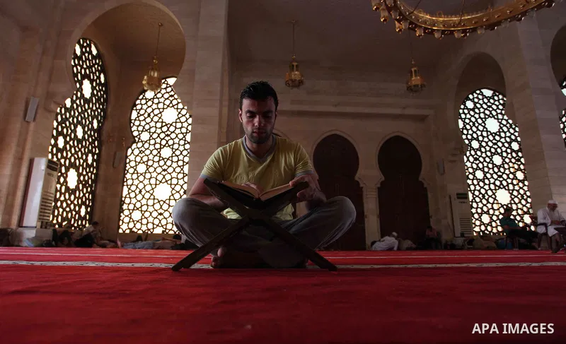 A Palestinian man reads the Koran, Islam's holiest book, at a mosque in Gaza City during the Muslim holy month of Ramadan, on June 6, 2018. Ramadan is sacred to Muslims because it is during that month that tradition says...