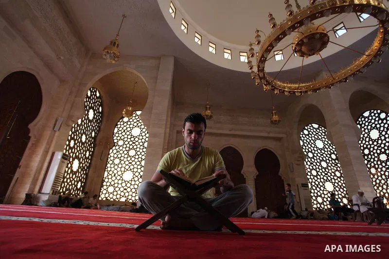 A Palestinian man reads the Koran, Islam's holiest book, at a mosque in Gaza City during the Muslim holy month of Ramadan, on June 6, 2018. Ramadan is sacred to Muslims because it is during that month that tradition says...