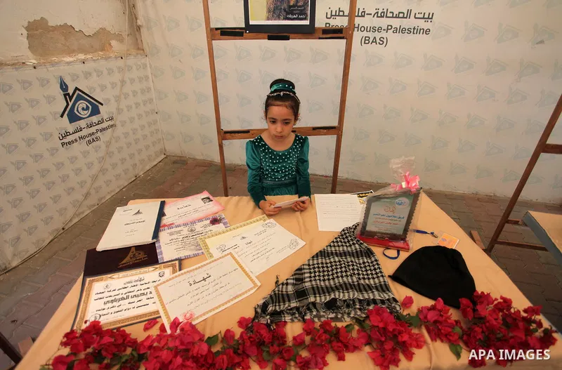 Palestinians attend an exhibition collectibles of martyrs journalists, in Gaza City on May 7, 2016. Photo by Mahmoud Ajour