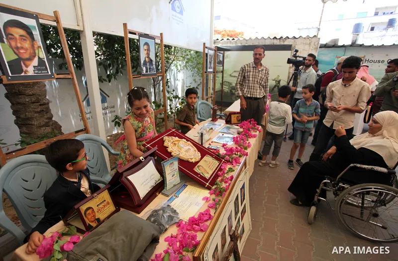Palestinians attend an exhibition collectibles of martyrs journalists, in Gaza City on May 7, 2016. Photo by Mahmoud Ajour