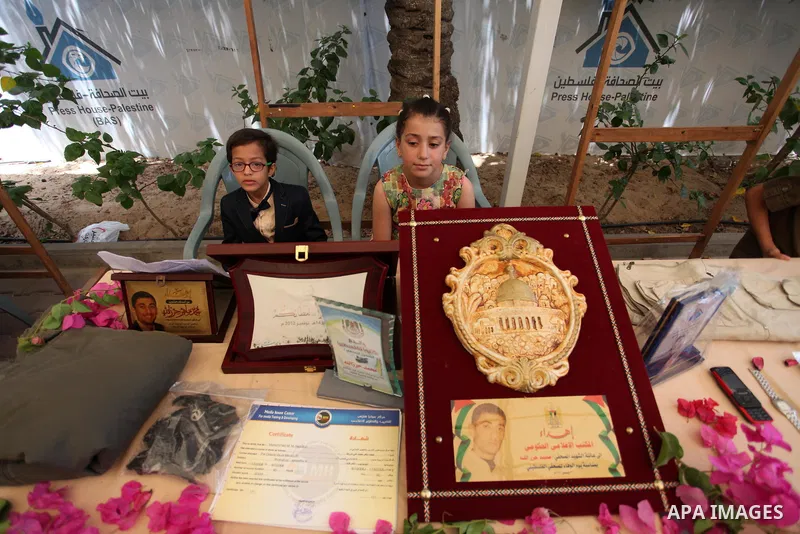 Palestinians attend an exhibition collectibles of martyrs journalists, in Gaza City on May 7, 2016. Photo by Mahmoud Ajour