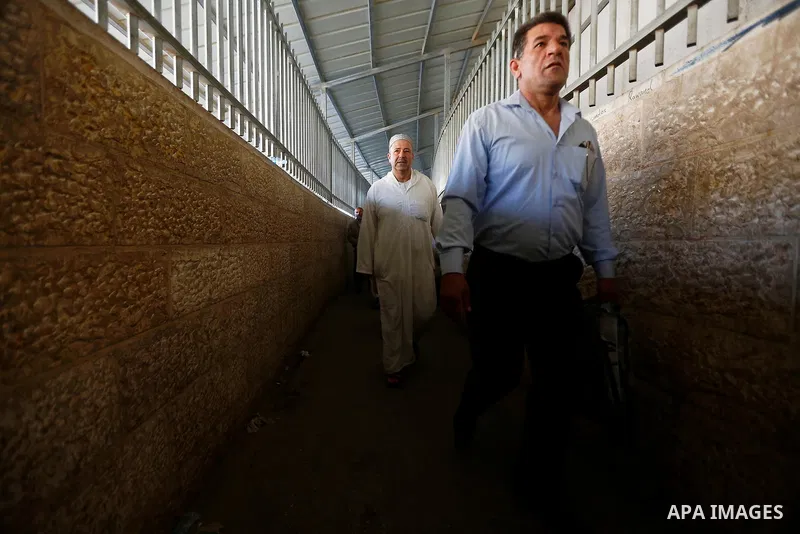 Palestinians make their way through an Israeli checkpoint along Israel's controversial separation barrier to attend the last Friday prayer of the holy fasting month of Ramadan in Jerusalem's Al-Aqsa mosque, in Bethlehem...