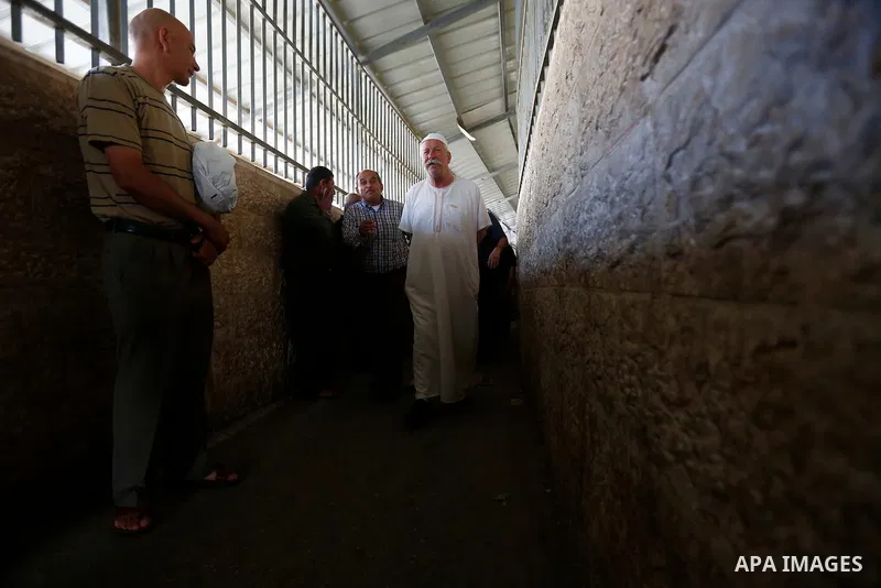 Palestinians make their way through an Israeli checkpoint along Israel's controversial separation barrier to attend the last Friday prayer of the holy fasting month of Ramadan in Jerusalem's Al-Aqsa mosque, in Bethlehem...