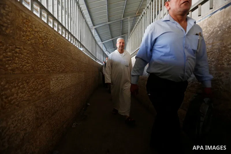 Palestinians make their way through an Israeli checkpoint along Israel's controversial separation barrier to attend the last Friday prayer of the holy fasting month of Ramadan in Jerusalem's Al-Aqsa mosque, in Bethlehem...