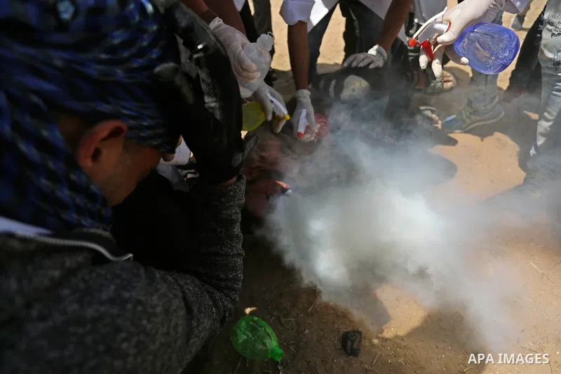 A wounded Palestinian protester reacts as he is hit in the face with a tear gas canister fired by Israeli troops during a protest marking al-Quds Day, (Jerusalem Day), at the Israel-Gaza border in Khan Younis in the sout...