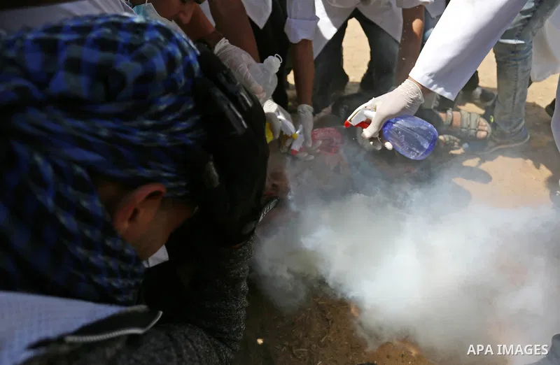 A wounded Palestinian protester reacts as he is hit in the face with a tear gas canister fired by Israeli troops during a protest marking al-Quds Day, (Jerusalem Day), at the Israel-Gaza border in Khan Younis in the sout...