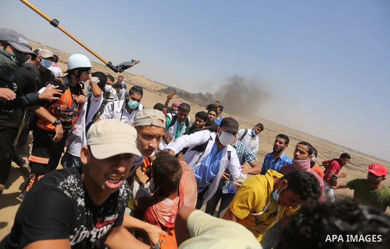 A wounded Palestinian protester reacts as he is hit in the face with a tear gas canister fired by Israeli troops during a protest marking al-Quds Day, (Jerusalem Day), at the Israel-Gaza border in Khan Younis in the sout...