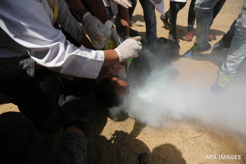 A wounded Palestinian protester reacts as he is hit in the face with a tear gas canister fired by Israeli troops during a protest marking al-Quds Day, (Jerusalem Day), at the Israel-Gaza border in Khan Younis in the sout...