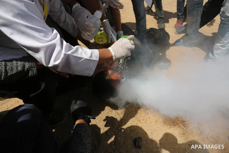A wounded Palestinian protester reacts as he is hit in the face with a tear gas canister fired by Israeli troops during a protest marking al-Quds Day, (Jerusalem Day), at the Israel-Gaza border in Khan Younis in the sout...