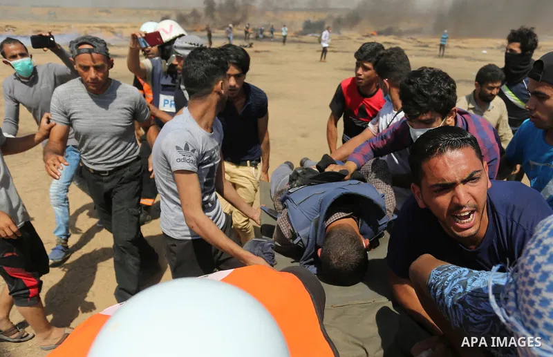 A wounded Palestinian Journalist is evacuated during clashes with Israeli security froces in a protest marking al-Quds Day, (Jerusalem Day), at the Israel-Gaza border in Khan Younis in the southern Gaza Strip on June 8,...