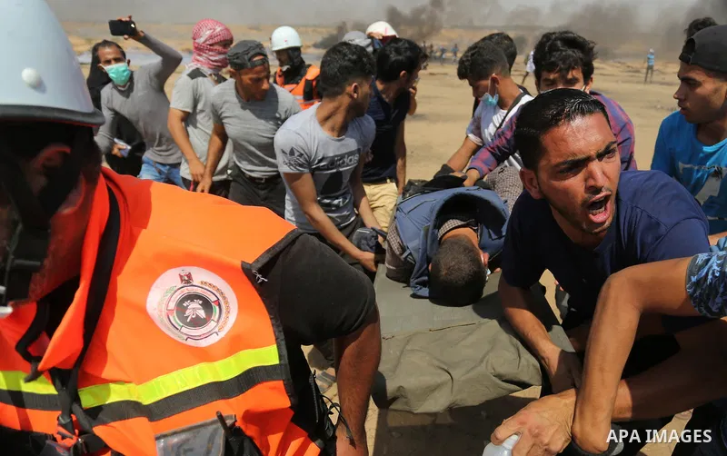 A wounded Palestinian Journalist is evacuated during clashes with Israeli security froces in a protest marking al-Quds Day, (Jerusalem Day), at the Israel-Gaza border in Khan Younis in the southern Gaza Strip on June 8,...