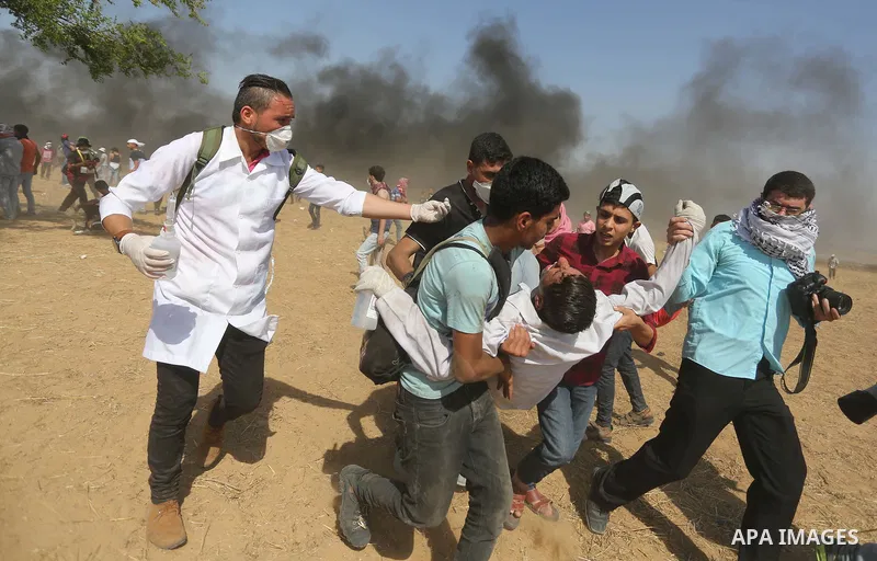 A wounded Palestinian Medic is evacuated during clashes with Israeli security froces in a protest marking al-Quds Day, (Jerusalem Day), at the Israel-Gaza border in Khan Younis in the southern Gaza Strip on June 8, 2018....