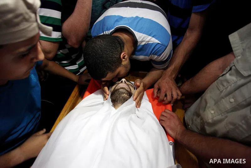 Palestinian relatives mourn over the body of Yussef al-Faseeh, 29, who was shot dead by Israeli troops during clashes at Israel-Gaza border, during his funeral in Gaza city on on 9, 2018. Four Palestinians were killed by...