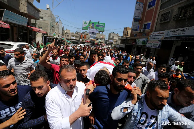 Mourners carry the body of Palestinian Ziad al-Barim, 25, who was shot dead by Israeli troops during clashes at Israel-Gaza border, during his funeral in Khan Younis in the southern Gaza strip on June 9, 2018. Four Pales...