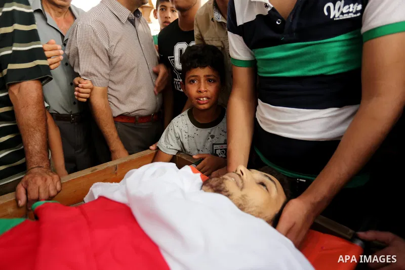 Palestinian relatives mourn over the body of Ziad al-Barim, 25, who was shot dead by Israeli troops during clashes at Israel-Gaza border, during his funeral in Khan Younis in the southern Gaza strip on June 9, 2018. Four...