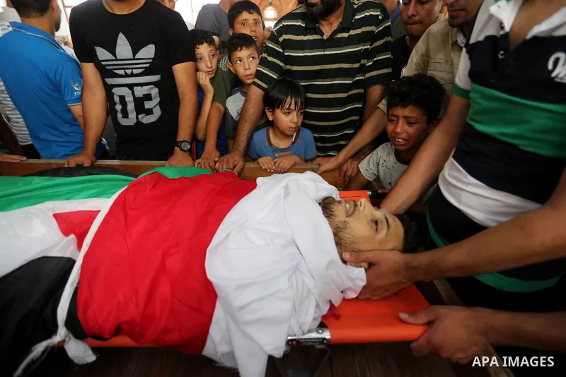 Palestinian relatives mourn over the body of Ziad al-Barim, 25, who was shot dead by Israeli troops during clashes at Israel-Gaza border, during his funeral in Khan Younis in the southern Gaza strip on June 9, 2018. Four...