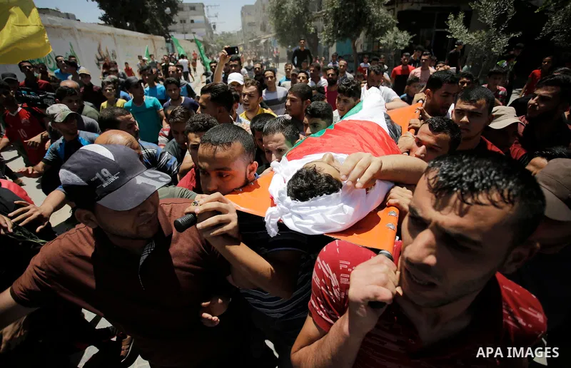 Mourners carry the body of Palestinian Haitham al-Jamal, 15, who was shot dead by Israeli troops during clashes, during his funeral in Rafah in the southern Gaza Strip on June 9, 2018. Four Palestinians were killed by Is...