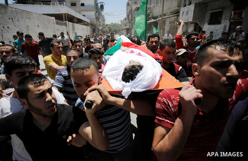 Mourners carry the body of Palestinian Haitham al-Jamal, 15, who was shot dead by Israeli troops during clashes, during his funeral in Rafah in the southern Gaza Strip on June 9, 2018. Four Palestinians were killed by Is...