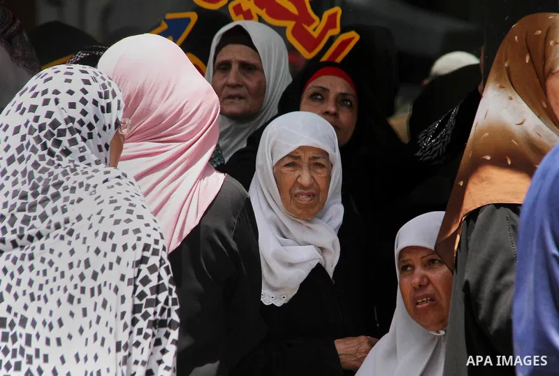 Palestinians of Social Affairs wait in front of Bank of Palestine to withdraw their financial aid in Gaza City on June 10, 2018. Photo by Mahmoud Ajour