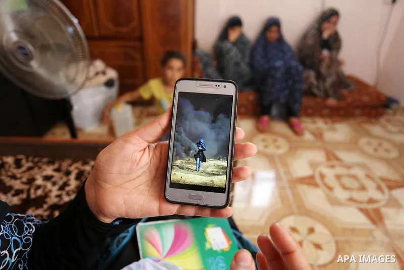 The mother of Palestinian Wesal Sheikh Khalil, 15, who was shot dead by Israeli troops during clashes at Israel-Gaza border holds a mobile phone and showing the picture of her daughter at their home at al-Maghazi camp in...