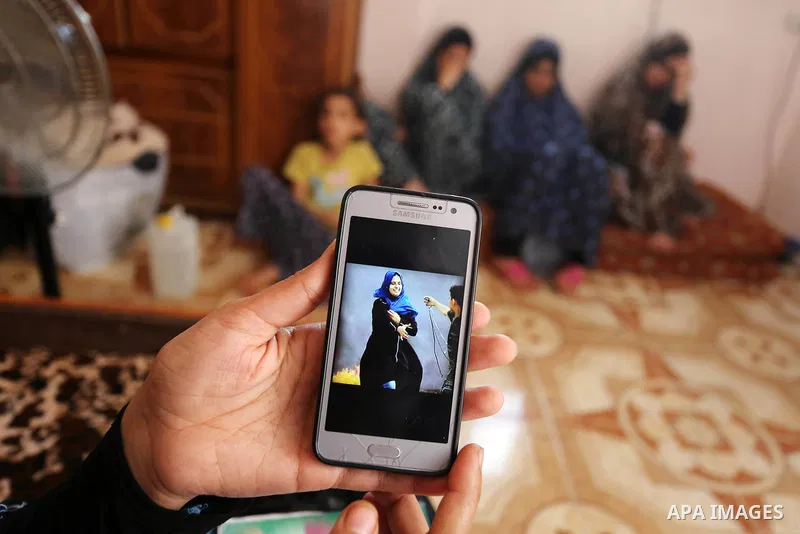 The mother of Palestinian Wesal Sheikh Khalil, 15, who was shot dead by Israeli troops during clashes at Israel-Gaza border holds a mobile phone and showing the picture of her daughter at their home at al-Maghazi camp in...