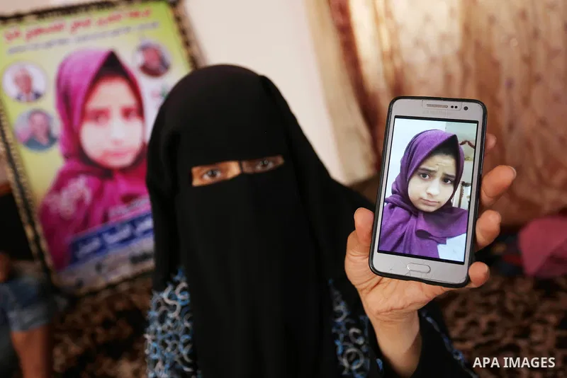 The mother of Palestinian Wesal Sheikh Khalil, 15, who was shot dead by Israeli troops during clashes at Israel-Gaza border holds a mobile phone and showing the picture of her daughter at their home at al-Maghazi camp in...