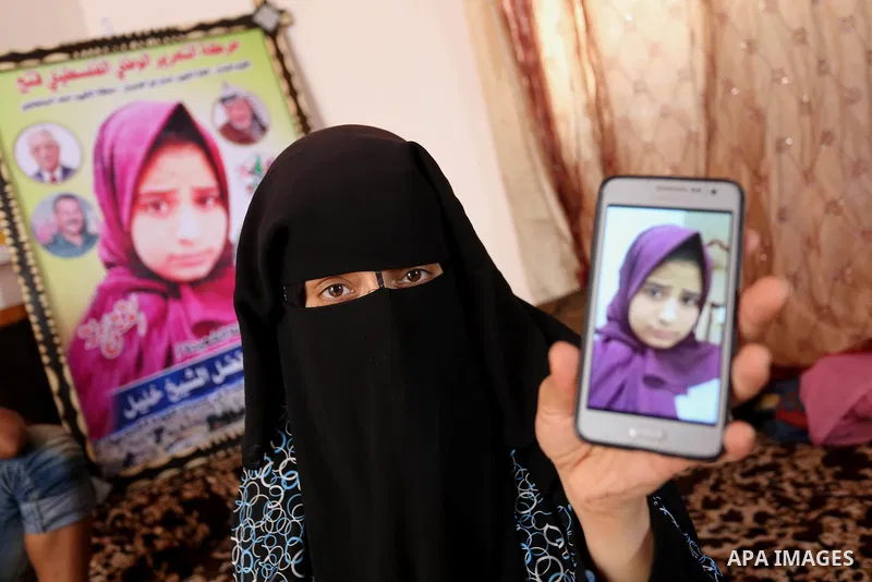 The mother of Palestinian Wesal Sheikh Khalil, 15, who was shot dead by Israeli troops during clashes at Israel-Gaza border holds a mobile phone and showing the picture of her daughter at their home at al-Maghazi camp in...