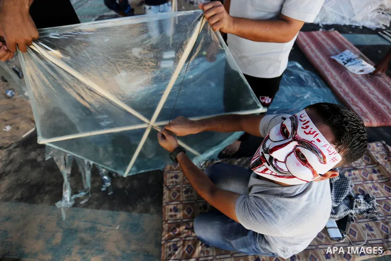 Palestinian protesters prepare kites loaded with flammable material to be flown towards Israel, at the Israel-Gaza border in al-Bureij in the center of Gaza Strip on June 11, 2018. Photo by Ashraf Amra