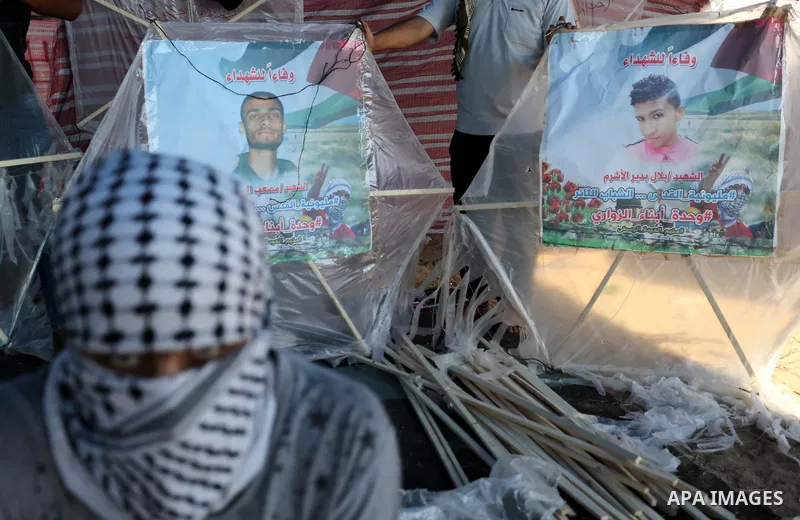 Palestinian protesters prepare kites loaded with flammable material to be flown towards Israel, at the Israel-Gaza border in al-Bureij in the center of Gaza Strip on June 11, 2018. Photo by Ashraf Amra