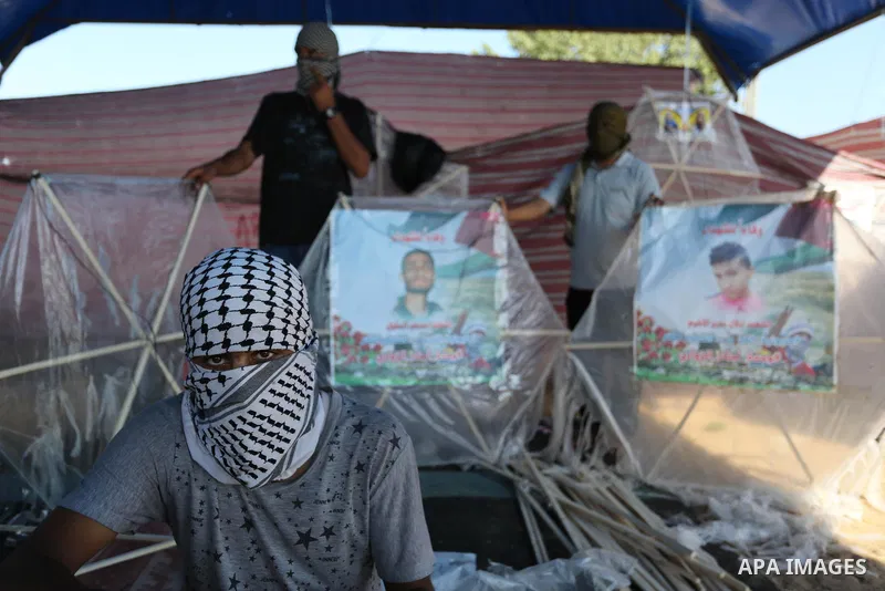 Palestinian protesters prepare kites loaded with flammable material to be flown towards Israel, at the Israel-Gaza border in al-Bureij in the center of Gaza Strip on June 11, 2018. Photo by Ashraf Amra