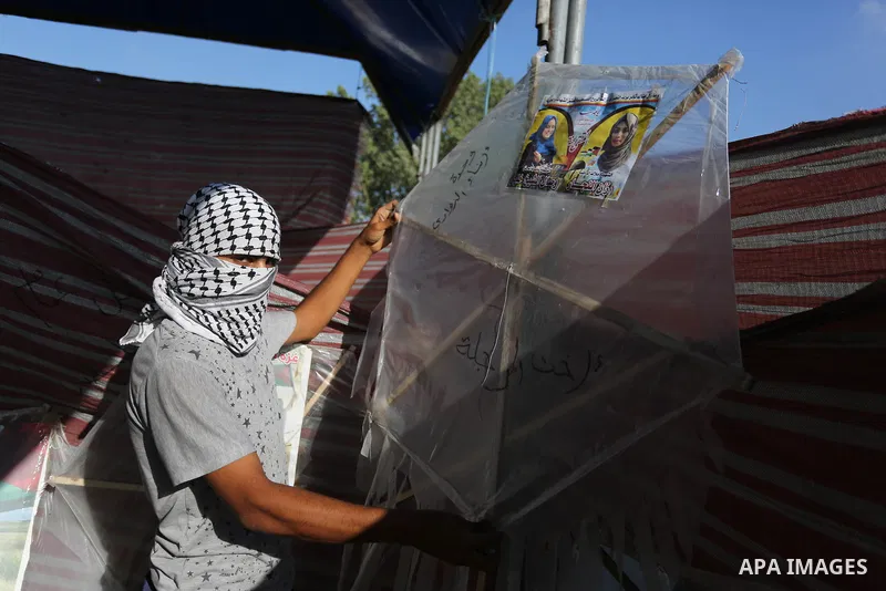 Palestinian protesters prepare kites loaded with flammable material to be flown towards Israel, at the Israel-Gaza border in al-Bureij in the center of Gaza Strip on June 11, 2018. Photo by Ashraf Amra