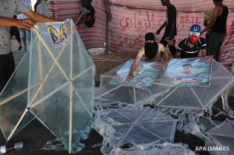 Palestinian protesters prepare kites loaded with flammable material to be flown towards Israel, at the Israel-Gaza border in al-Bureij in the center of Gaza Strip on June 11, 2018. Photo by Ashraf Amra
