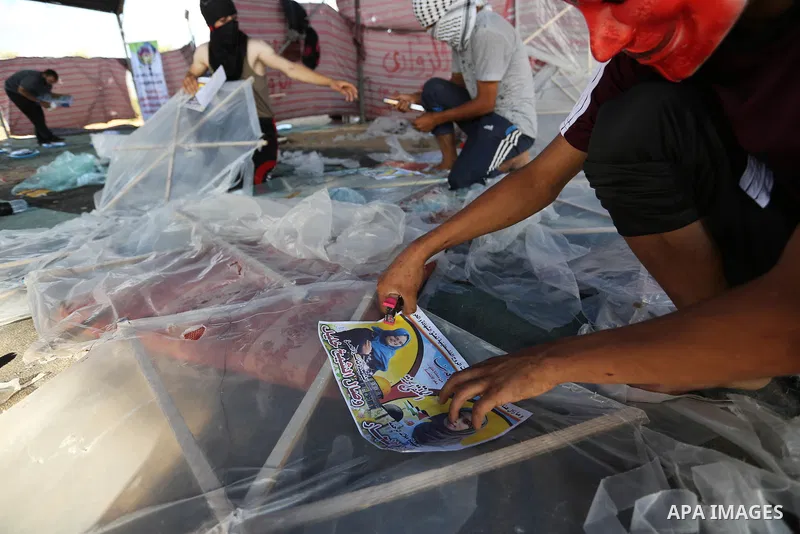 Palestinian protesters prepare kites loaded with flammable material to be flown towards Israel, at the Israel-Gaza border in al-Bureij in the center of Gaza Strip on June 11, 2018. Photo by Ashraf Amra