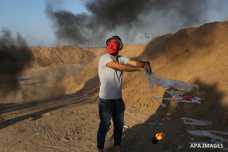 Palestinian protesters prepare kites loaded with flammable material to be flown towards Israel, at the Israel-Gaza border in al-Bureij in the center of Gaza Strip on June 11, 2018. Photo by Ashraf Amra