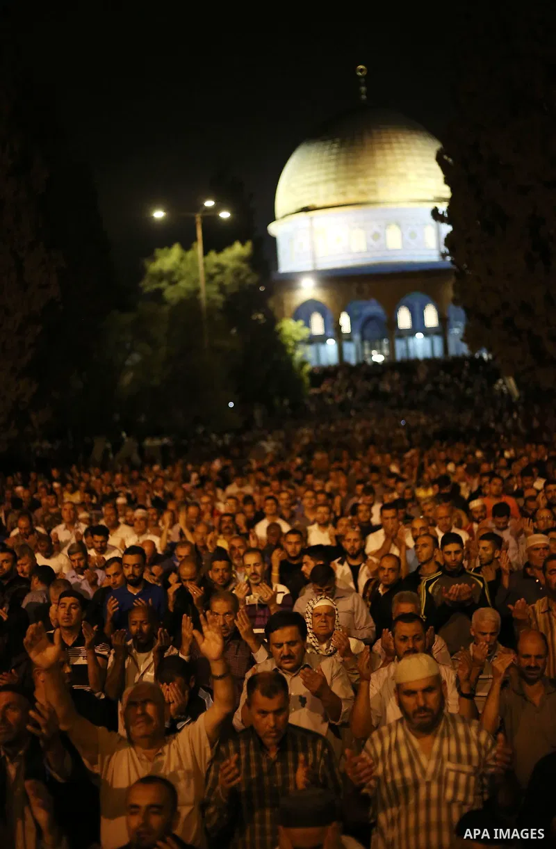Palestinian Muslim worshipers pray outside the Dome of the Rock in the Al-Aqsa mosques compound in Jerusalem's Old City on the occasion of Laylat al-Qadr, which falls on the 27th day of the fasting month of Ramadan on Ju...