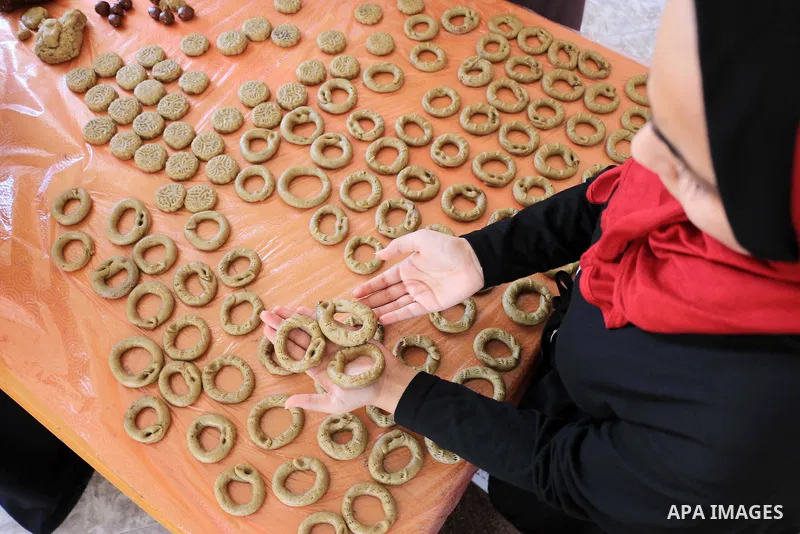 Palestinian women prepare traditional date-filled mini cakes to sell for customers a few days ahead of Eid al-Fitr holiday in Dair Al Balah, in the center of Gaza Strip on June 12, 2018. Eid al-Fitr marks the end of Musl...
