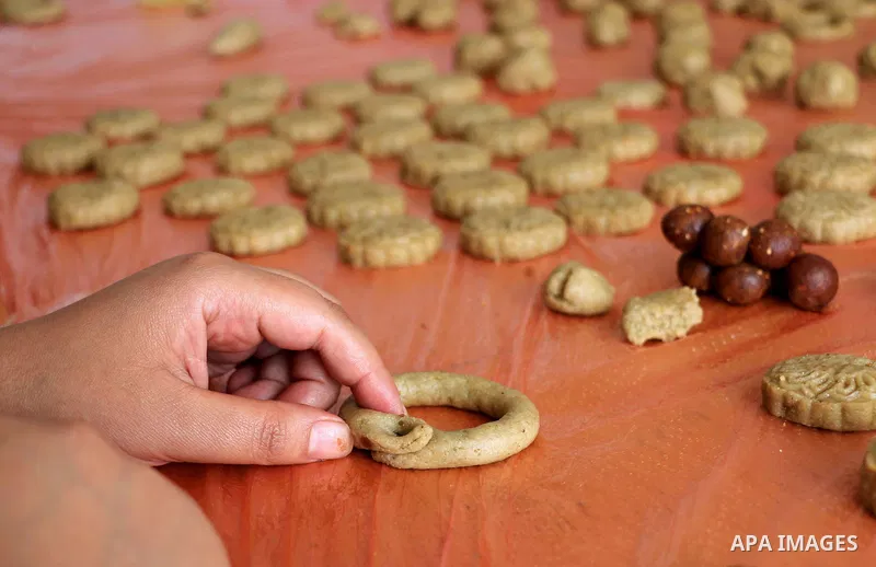 Palestinian women prepare traditional date-filled mini cakes to sell for customers a few days ahead of Eid al-Fitr holiday in Dair Al Balah, in the center of Gaza Strip on June 12, 2018. Eid al-Fitr marks the end of Musl...