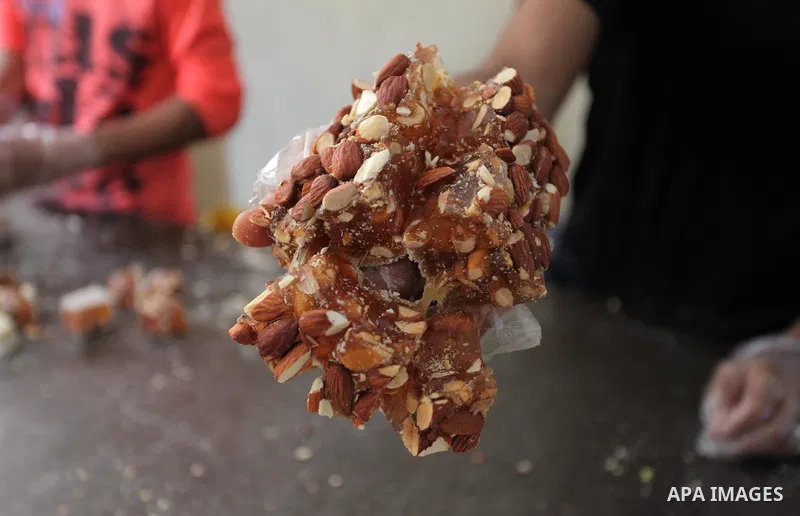 Palestinians prepare sweet known in Arabic as "Halkoum" in a store to be sold ahead of the Eid al-Fitr holiday in Gaza city on June 13, 2018. Eid al-Fitr marks the end of Muslim's holy fasting month of Ramadan when faith...
