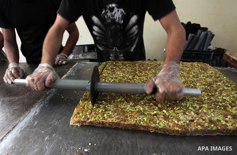 Palestinians prepare sweet known in Arabic as "Halkoum" in a store to be sold ahead of the Eid al-Fitr holiday in Gaza city on June 13, 2018. Eid al-Fitr marks the end of Muslim's holy fasting month of Ramadan when faith...