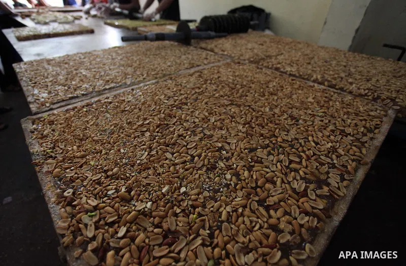 Palestinians prepare sweet known in Arabic as "Halkoum" in a store to be sold ahead of the Eid al-Fitr holiday in Gaza city on June 13, 2018. Eid al-Fitr marks the end of Muslim's holy fasting month of Ramadan when faith...