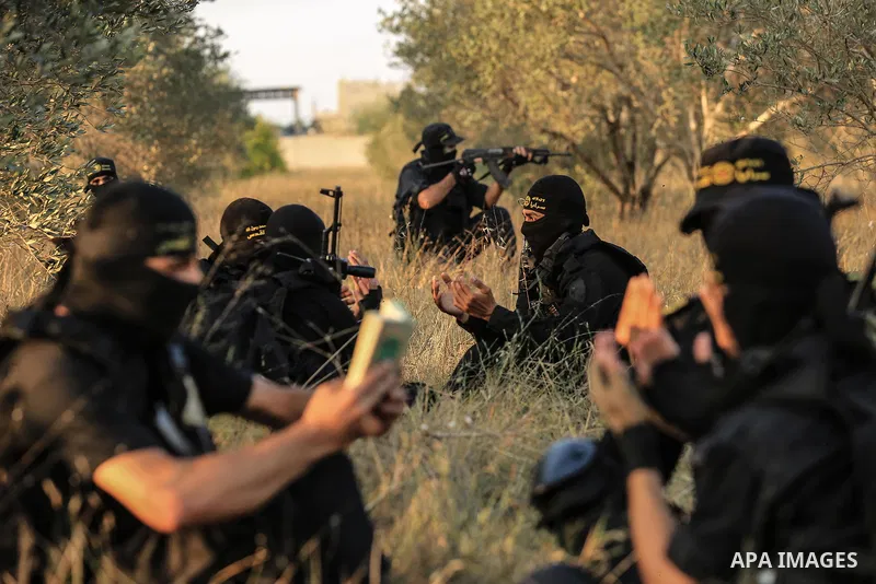 Palestinian militants from the Al-Quds Brigades, the armed wing of the Islamic Jihad movement pray at the border in the east of Gaza city on the Muslim holy fasting month of Ramadan on June 13, 2018. Ramadan is sacred to...